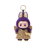 Purple plush keychain with a gold skirt on a white background - Image 1