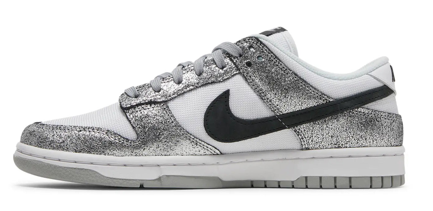 White sneaker with black swoosh logo and silver glittery side panel on a white background
