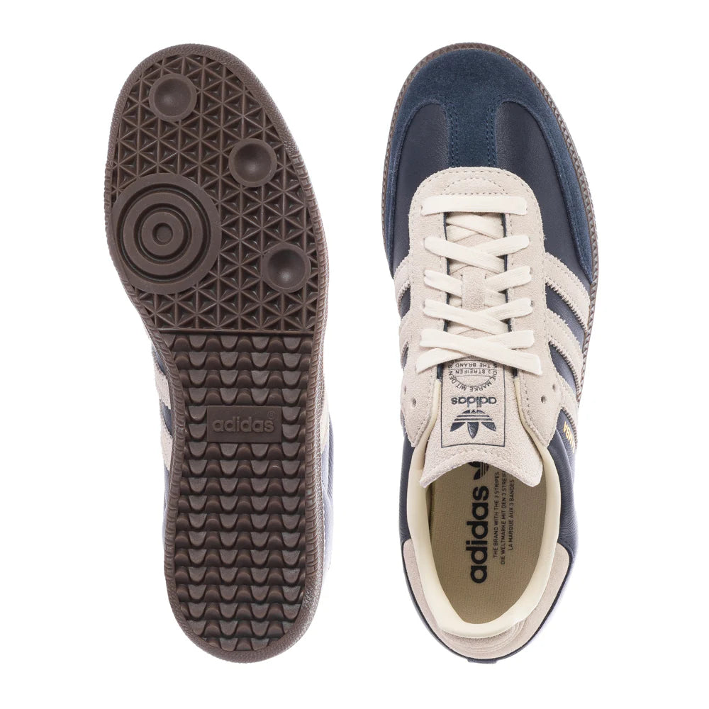 Navy and white Adidas sneakers showing sole and side view on a white background