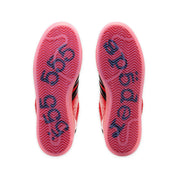 Close-up of red and black athletic shoes with brand logo on sole against a white background
