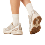 Beige sneakers with brown soles worn with white socks on a white background - Image 3