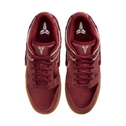 Pair of maroon sneakers with white accents on a white background